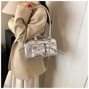 Silver metallic bow detail shoulder bag styled with beige blazer and white pleated skirt