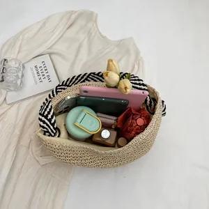 Handmade straw tote bag with striped handles showing large capacity for daily items