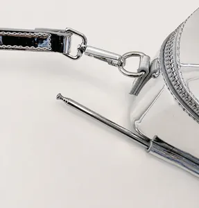 Macro shot of silver mirror leather phone bag with metal antenna and chrome hardware