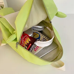 Grüner Kinderrucksack mit Monster-Elementen zeigt geräumiges Innenfach für Snacks