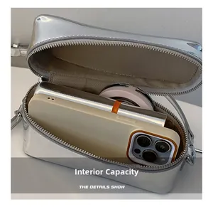 Internal capacity of silver metallic crossbody bag showing phone and cosmetics fit