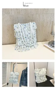 Dettagli della borsa tote in pizzo bianco con fiori blu e balze multistrato