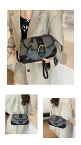 Detailed view of retro grey denim patchwork bag with a large gold buckle and leather strap