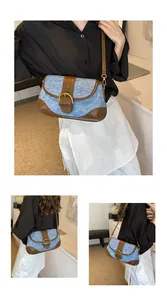 Detail of vintage denim and brown leather patchwork shoulder bag with gold buckle