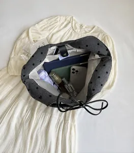 Interior view of large capacity grey polka dot tote bag filled with tablets and umbrella