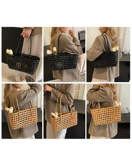 Detail van geweven tassen in zwart en camel met slanke dubbele handvatten