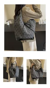 Detail of grey tote bag with black polka dots and sleek leather strap accents