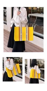 Detail of yellow felt tote bag featuring branded lettered webbing and leather trim accents