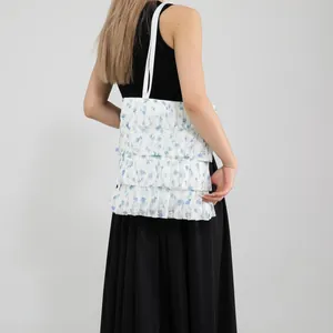 Borsa tote in pizzo a pieghe con motivi floreali blu e volant per uno stile estivo