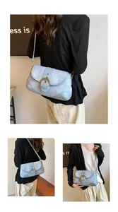 Detail of light blue denim shoulder bag featuring a large gold metal horseshoe buckle