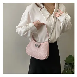 Macro shot of pink rhinestone shoulder bag with sparkling W buckle and metal chain strap