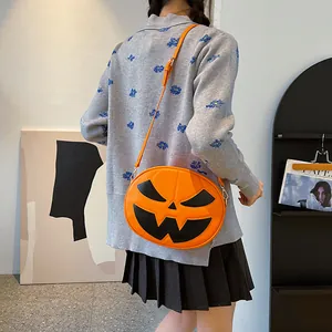 Vibrant orange pumpkin-shaped crossbody bag with a black Jack-o'-lantern face detail