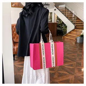Detailed view of the vibrant hot pink felt tote bag with wide logo-printed straps