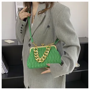 Green matelasse crossbody bag with vintage gold metal frame worn by a model