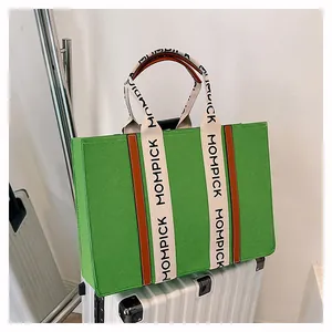 Detail of MOMPICK large felt tote bag featuring green texture and white branded straps