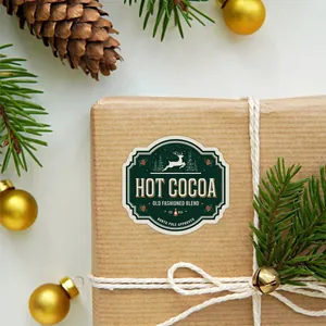 Detail eines Hot Cocoa Weihnachtsaufklebers auf Kraftpapierbox mit festlicher Dekoration
