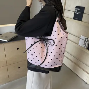 Pink canvas tote bag with black polka dots and bow pattern featuring black shiny base