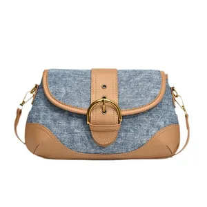 Vintage denim and brown leather patchwork shoulder bag with large gold buckle and strap