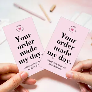 Close-up of a person holding two pink thank you cards for business gift packaging