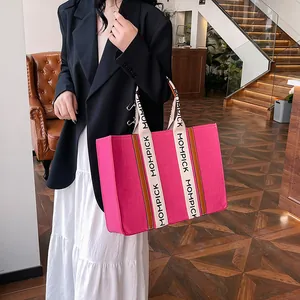 Large magenta felt tote bag with MOMPICK logo handle in a stylish indoor setting