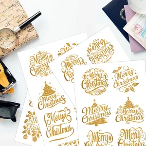 Detalle de pegatinas navideñas UV doradas con motivos festivos de árboles y campanas