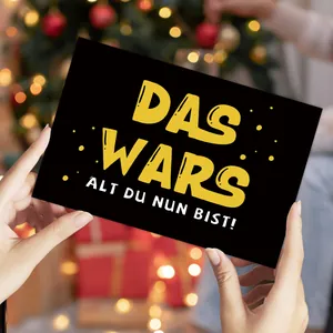 Détail d'une carte d'anniversaire drôle style Star Wars tenue à la main sur fond de fête
