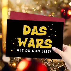 Gros plan détaillé d'une carte de Noël noire amusante avec texte allemand et enveloppe