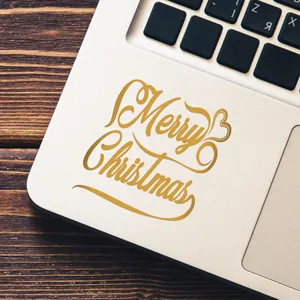 Detalle de la pegatina de transferencia UV dorada de Feliz Navidad en un ordenador portátil