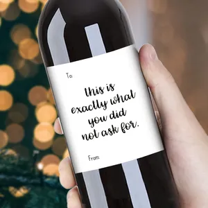 Gros plan d'une étiquette de vin de Noël amusante sur une bouteille tenue par la main