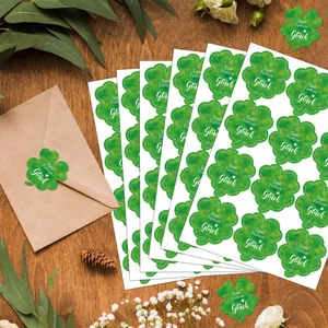Détail d'autocollants trèfle à quatre feuilles verts sur une enveloppe en papier kraft