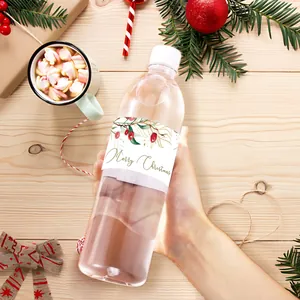 Close-up of festive water bottle label with Merry Christmas text and berry decorations