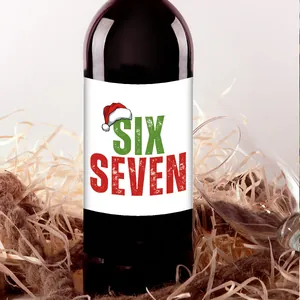Primer plano de botella de vino con etiquetas navideñas sobre fondo de rafia rústica
