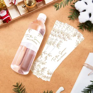 Detail of gold foil Christmas water bottle labels with Tis the Season festive typography