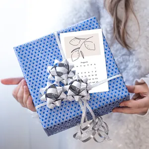 Minimalist 2026 calendar card with lemon illustration on a blue gift box with silver ribbon