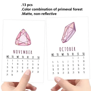 Close-up of hand holding matte 2026 calendar cards with crystal gem illustrations