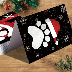 Christmas cards with dog paw prints and Santa hats on a rustic wooden tabletop