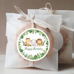 Close-up of watercolor jungle animal birthday stickers on a white gift bag with ribbon