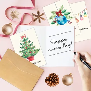 Detail of Christmas cards with watercolor trees and kraft envelopes on festive background