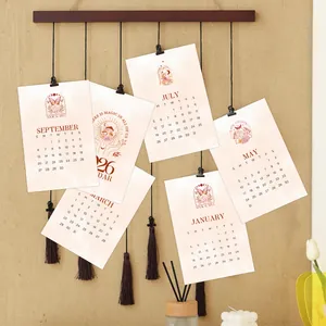 Detail van de boho-kalenderkaarten 2026 met magische illustraties op houten wandhanger