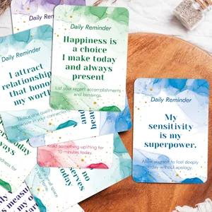 Set of 60 colorful daily affirmation cards with gold glitter on a wooden tray