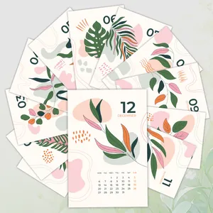 Macro view of 12-month botanical calendar cards with minimalist aesthetic plant designs