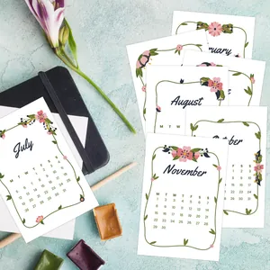 Macro view of aesthetic 2026 monthly calendar cards with floral borders and artistic font