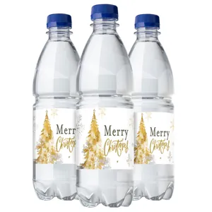 Close-up van drie waterflessen met gouden kerstboometiketten en de tekst Merry Christmas
