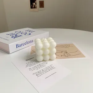 Macro shot of minimalist cube bubble soy wax candle on a book in a home setting