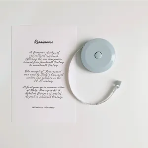 Detailed view of a mini blue retractable measuring tape with a decorative art card