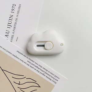 Macro detail of a white cloud-shaped mini utility knife with a push-pull safety slider
