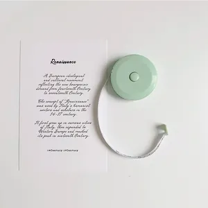 Close-up of mint green mini retractable tape measure with white fiber scale on a desk