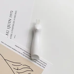 Close-up of white rabbit-shaped craft knife on minimalist art background cards