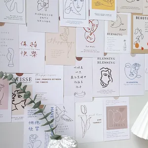Detail of minimalist line art cards featuring Matisse style faces and tulips on a wall