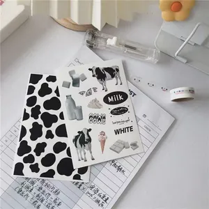 Close-up of cow print stickers with milk bottle motifs and black white stationery patterns